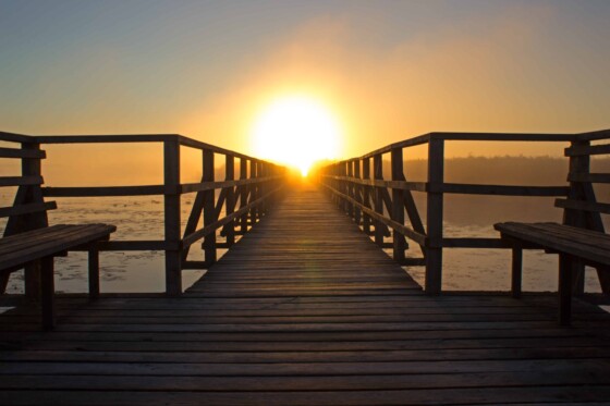 A sunset at the end of an empty pier.