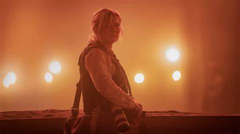 Lee standing in an area surrounded by orange lights, camera slung over her shoulder.